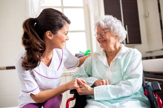 Nurse attending senior woman in a long term care facility, concept of trust