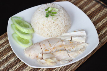 hainamese chicken rice with chopped chicken meat and cucumber slices