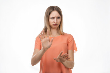 Displeased blond woman shows hands in stop or no gesture, denies problems, ignores something or...