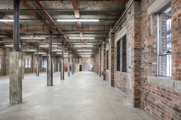 Interior old industrial shed brick walls concrete floor retro exposed ceiling pylon pillars empty