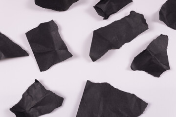 crumpled black sheets lie on the white floor