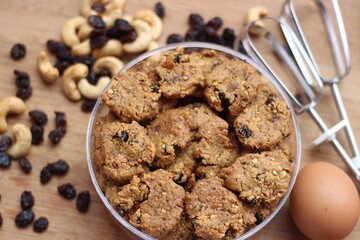 chocolate cookies with raisins and peanuts on a wooden table