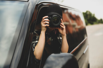 Private detective with camera spying from car