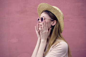 Pretty woman in sunglasses fashion hat walk pink wall