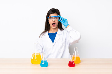 Young scientific woman in a table with glasses and surprised