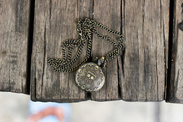 one piece vintage pocket watch with skull engraving on a wooden table