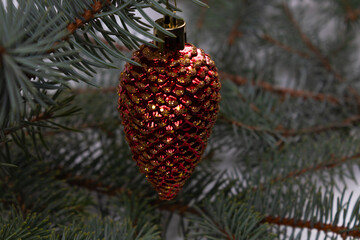 a toy in the form of a pine cone hanging on a tree close-up view