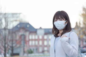 東京駅に通勤するマスクをした女性