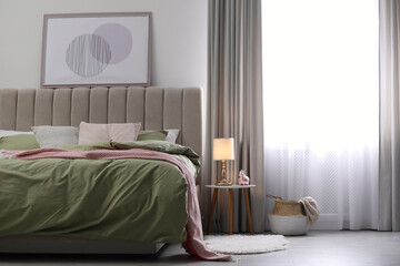 Comfortable bed with new pistachio linens in modern room interior