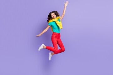 Fototapeta na wymiar Full length photo of shiny adorable wavy young woman dressed pullover shoulders jumping rising arm isolated purple color background