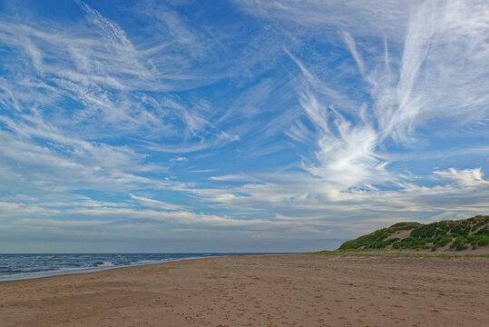 Looking south down the Ythan Estuary Beach on the East Coast of Scotland with dramatic high level clouds on a blue Sky above.