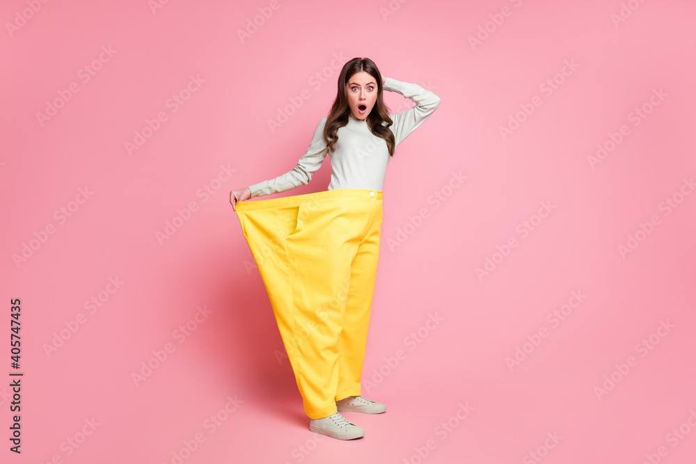 Poster Full body profile portrait of impressed curly hairstyle lady open mouth show how big pants isolated on pink color background