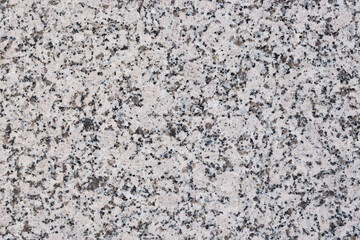 Granite texture. Natural granite with a grainy pattern. Stone background. Solid rough surface of rock. Durable construction and decoration material. Close-up.