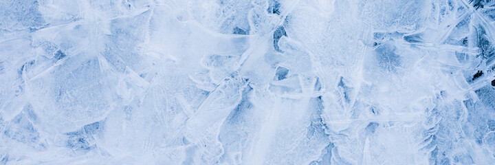 Fototapeta na wymiar Ice texture. Beautiful winter frosty background. Cool ice patterns on the frozen surface of the water. Cold weather and frost. Winter season. Wide panoramic texture for background and design.