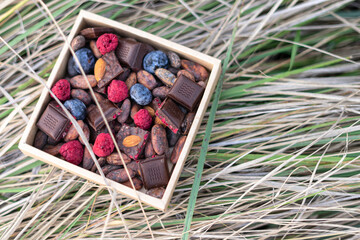Chocolate bars handmade with strawberries and pistachios on a black background. Craft vegan...