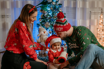 Beautiful young family mother and father with little baby girl child at home christmas holidays vibes and lifestyle