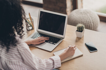 Photo portrait back rear spine view of woman working on laptop with blank space writing in notebook indoors