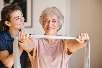 Physiotherapist working with happy senior patient at home