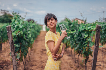 Portrait of a gorgeous brunette woman having wine fun in the vineyards on wine tasting