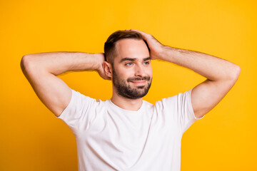 Fototapeta na wymiar Portrait of attractive groomed content guy caressing soft smooth hair isolated over bright yellow color background