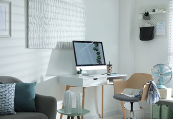 Comfortable office chair near desk with modern computer indoors