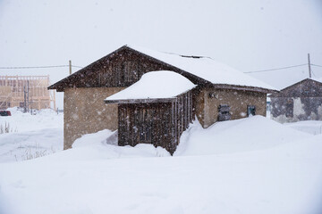 wooden house under snow cover in the winter time