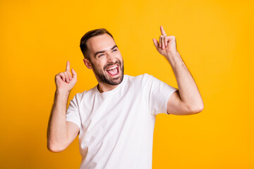 Portrait of attractive cheerful guy dancing having fun rest isolated over bright yellow color background