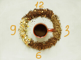 The dial is from different types of dry tea, in the middle of a mug of tea a. Tea time concept.