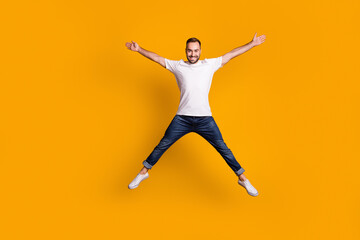 Fototapeta na wymiar Full length body size view of nice carefree cheerful guy jumping having fun isolated over bright yellow color background