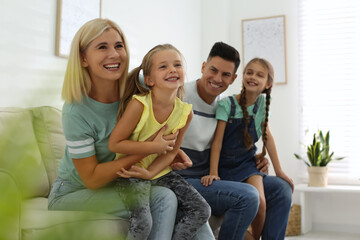 Happy family with children on sofa indoors