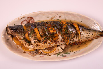 Fish on a platter stuffed with lemon view from afar