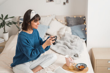 Young girl with retro photo camera at home taking photos. Female blogger   making photo for blog vlog