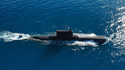 Aerial drone photo of latest technology  armed diesel powered submarine cruising half submerged