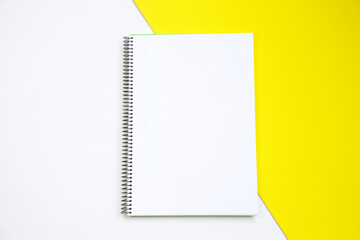 Top view of an open notebook against white and yellow background