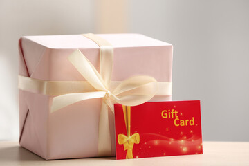 Gift card and present on table against blurred background