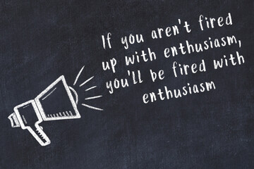 Chalk loudspeaker and wise quote on black desk