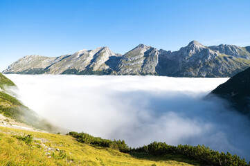 Alpine landscape with rocky mountains above fog at a sunny day in the Karwendel. Tirol, Austria
