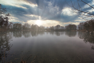 German lake in winter at sunset with reflection in the water