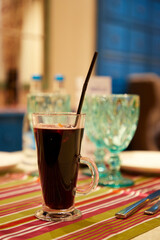 glass of mulled wine on table of cafe on blurred background of empty glasses