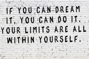 White brick wall with painted black inscription of wise quote