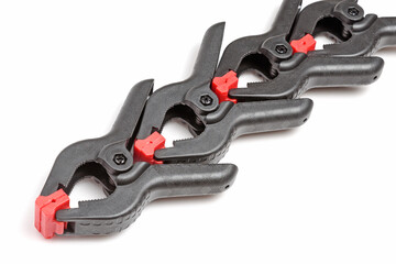 Top view of three spring clamps on a white background close-up