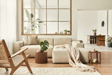 Fotobehang Hotel chique Modern interior of open space with design modular sofa, furniture, wooden coffee tables, plaid, pillows, tropical plants and elegant personal accessories in stylish home decor. Neutral living room.  © FollowTheFlow