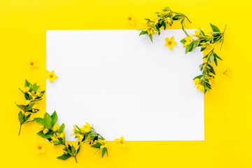 White paper blank with yellow spring flowers, overhead view