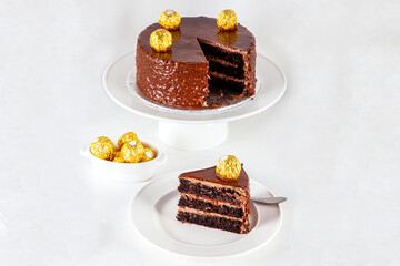 Three tier chocolate hazelnut cake with frosting and golden balls decoration