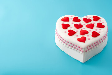 Heart cake for St. Valentine's Day, Mother's Day, or Birthday, decorated with sugar hearts on blue background	