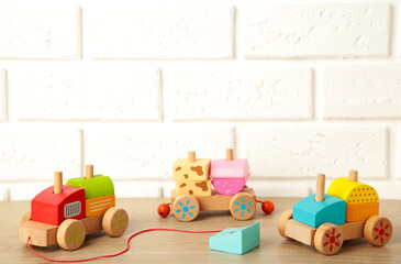 Stacking train toddler toy for little children on light background with shadow reflection.
