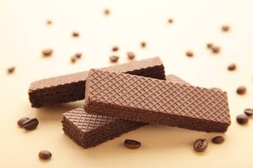 Chocolate wafers with coffee on beige background