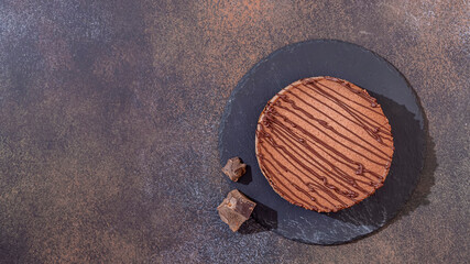 Classic chocolate cheesecake on a dark background. Homemade baking.