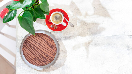 Classic chocolate cheesecake and a cup of coffee on light gray concrete background. Homemade baking.
