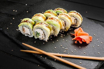 Avocado sushi rolls with cream cheese on black background
